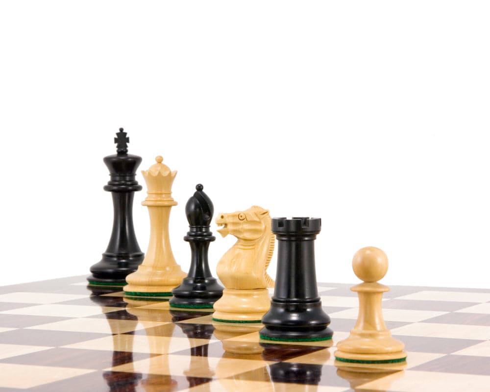 Old English Elite Series Ebony Staunton Chess Pieces on chessboard, featuring 3.5 inch king, additional queens, and weighted balanced bases.