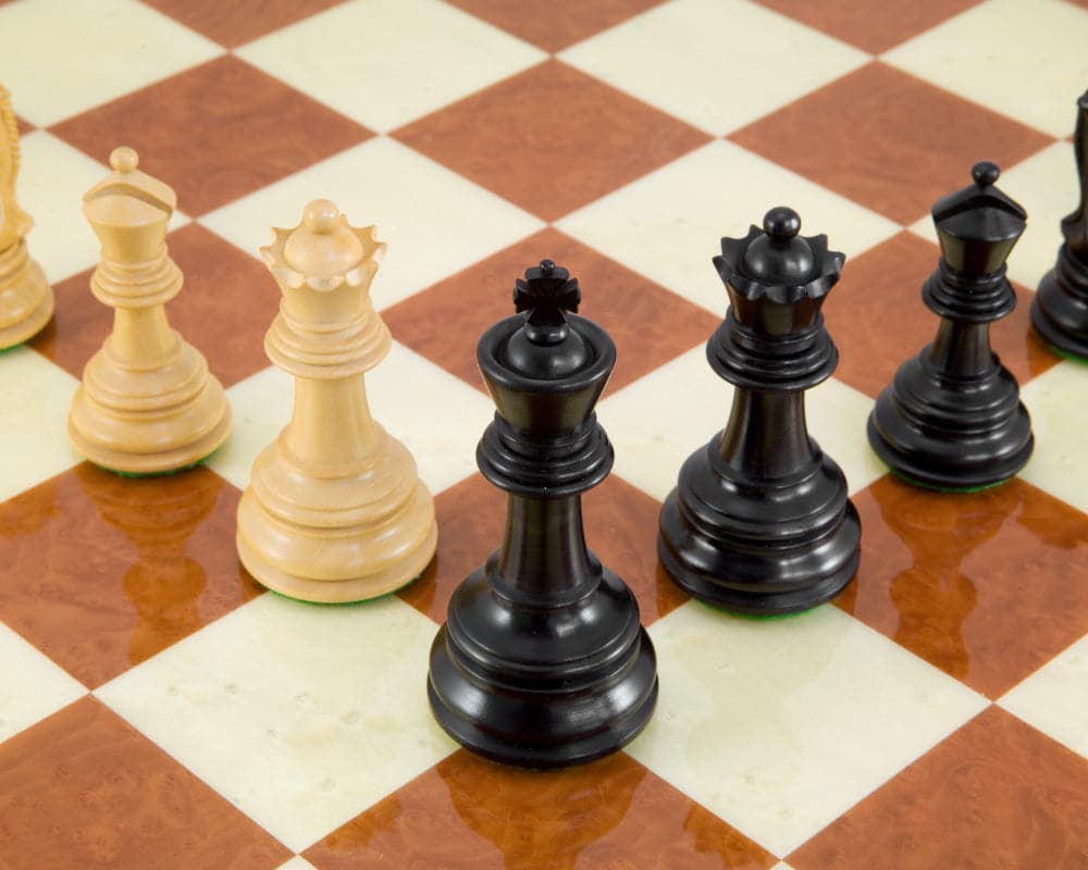 Handcrafted Cheltenham Series ebony and boxwood chess pieces with weighted bases on a chessboard.