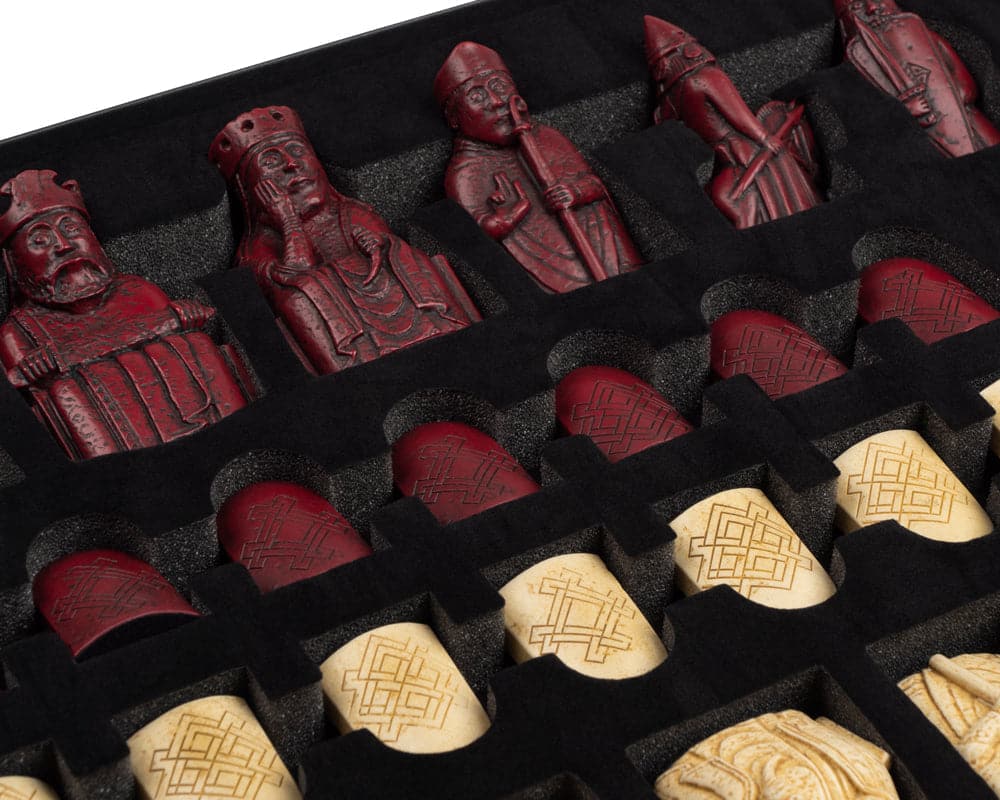 Red and ivory Isle of Lewis chessmen set by The Regency Chess Company arranged in a black foam tray.