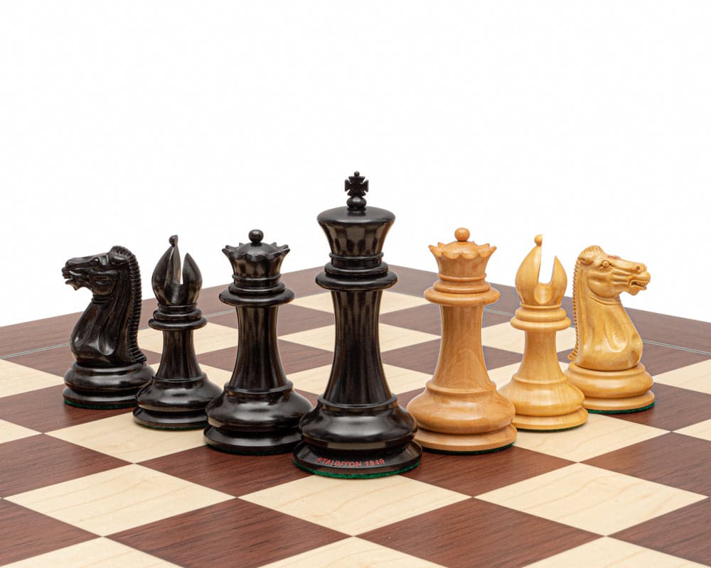 Original Staunton 1849 Ebony Chess Men 4.4 inch set with highly detailed black and yellow chess pieces on a chessboard.