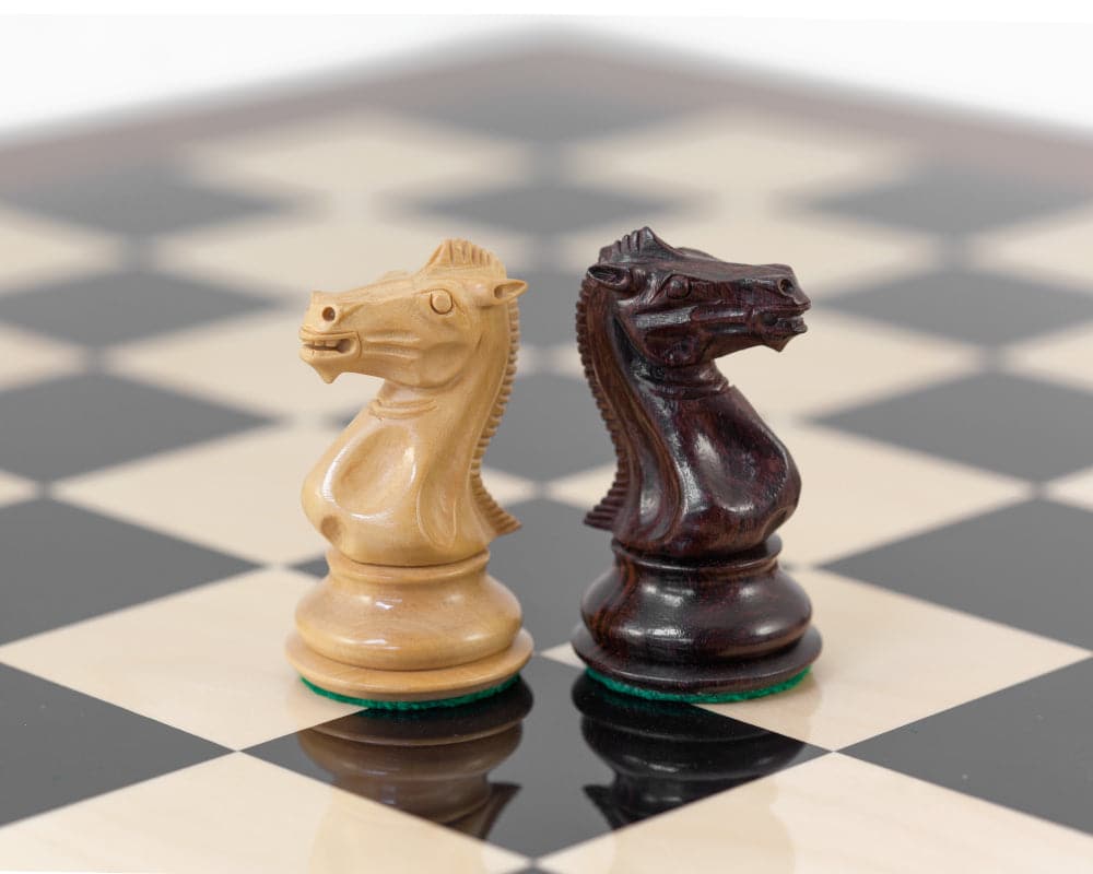 Two luxury Sandringham Indian Rosewood knight chess pieces on a high gloss rosewood and black Anegre chess board